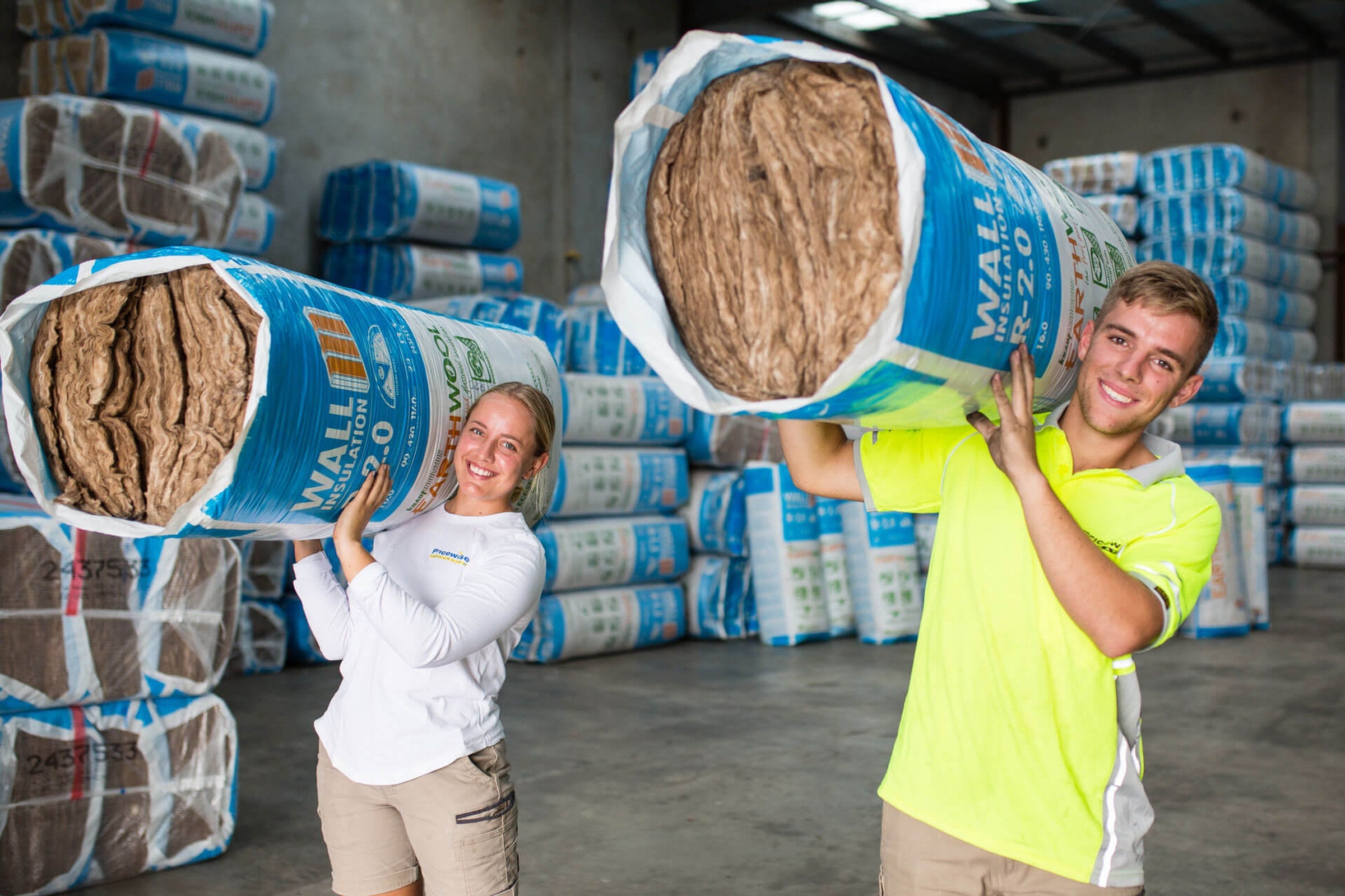 Pricewise staff carrying Knauf Earthwool wall insulation in the warehouse