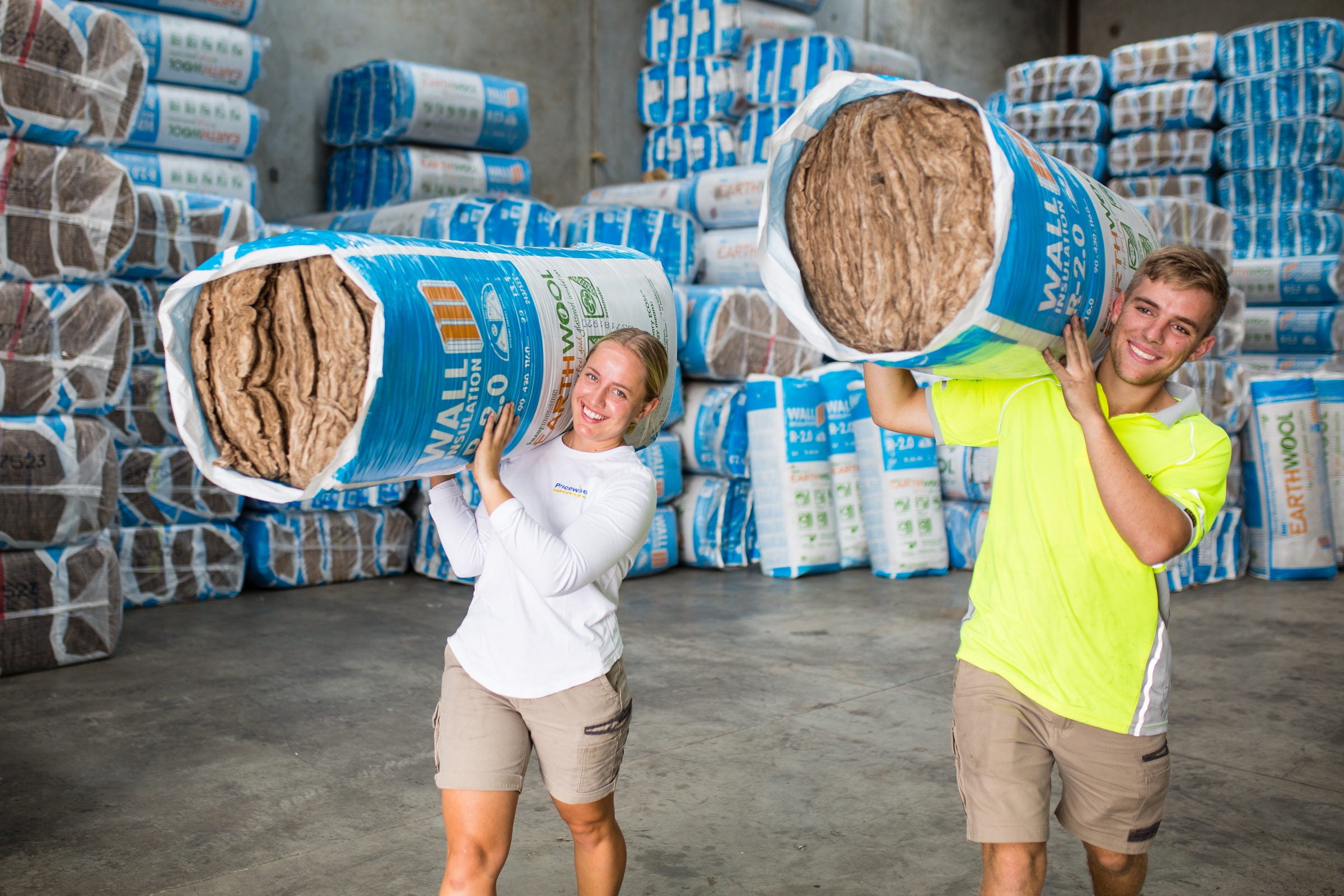 Pricewise staff carrying Knauf Earthwool wall insulation in the warehouse